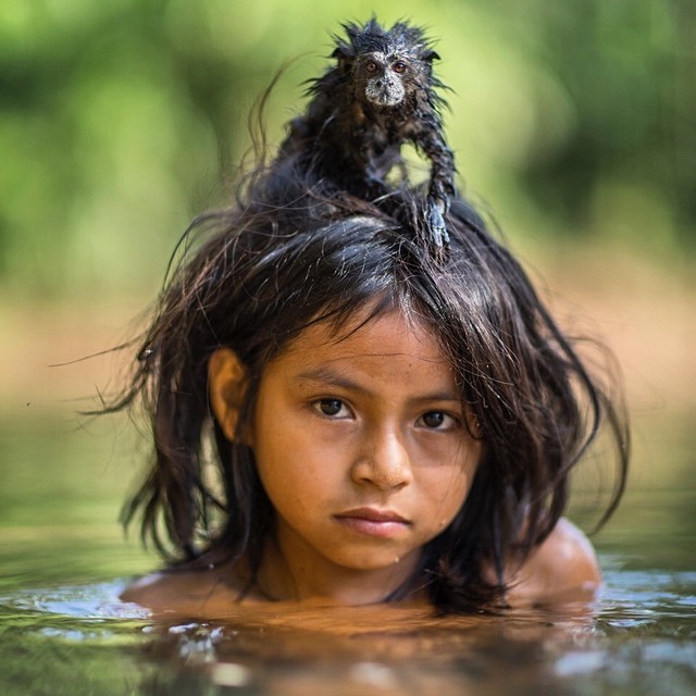  Yoina, a 9 year old girl of the Machiguenga community from the Peruvian Amazon, with her pet Saddle-back Tamarin 